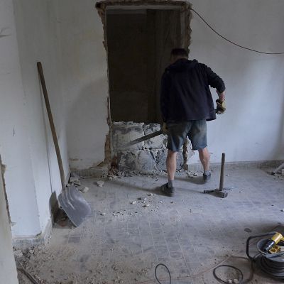 2018 05 : Přestavba opuštěného obchodu na kavárnu Nové Perly. Ladislav Hájek vybourává zazděné dveře. (fotografie Kler Miškovcová)